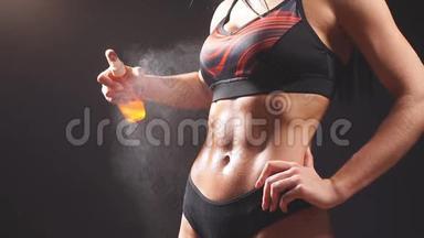 女孩运动的外表从一瓶身体油中喷出来。 体育概念